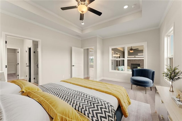 bedroom featuring baseboards, a raised ceiling, light colored carpet, ornamental molding, and a brick fireplace