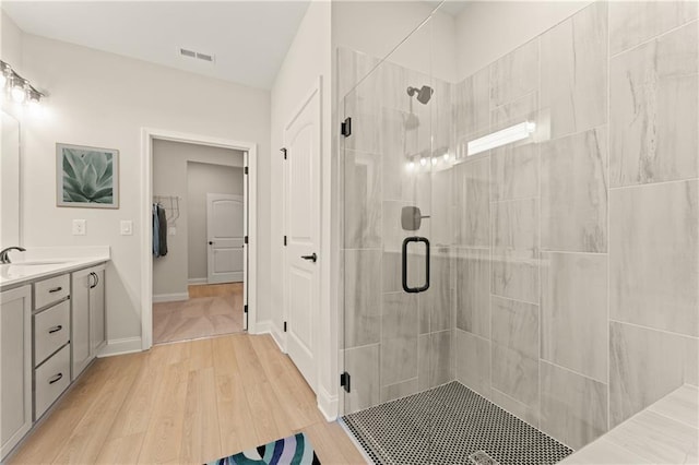 bathroom with a stall shower, visible vents, vanity, and wood finished floors