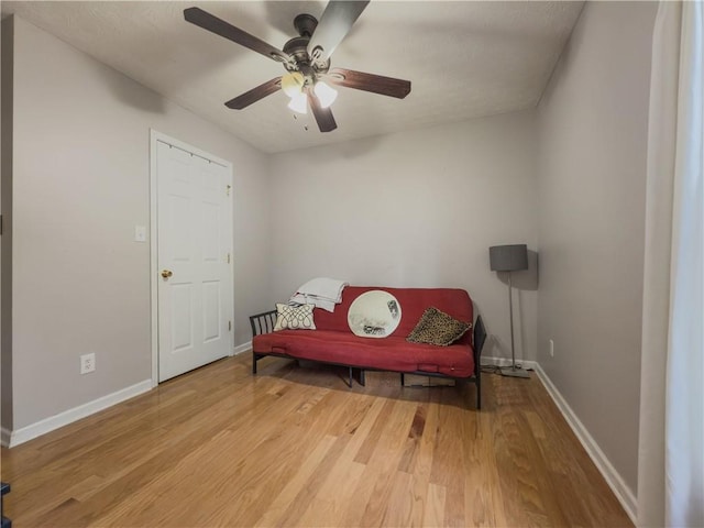 living area with ceiling fan, wood finished floors, and baseboards