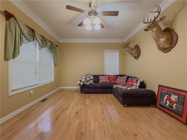 living area featuring light wood-style floors, baseboards, and ornamental molding