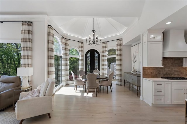 dining space with an inviting chandelier, light wood-type flooring, recessed lighting, and crown molding
