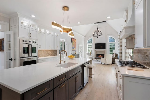 kitchen featuring white cabinetry, stainless steel appliances, light countertops, and a sink