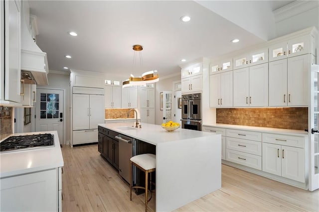 kitchen with crown molding, a sink, backsplash, and stainless steel appliances