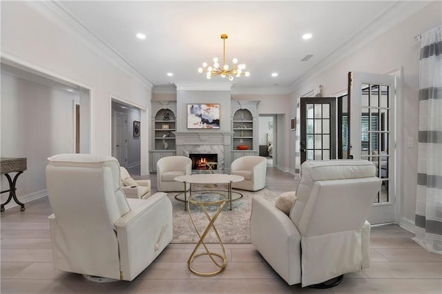 living area with an inviting chandelier, a fireplace, built in features, and baseboards
