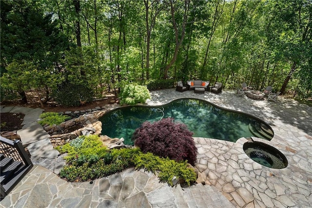 outdoor pool featuring a patio and an outdoor living space with a fire pit