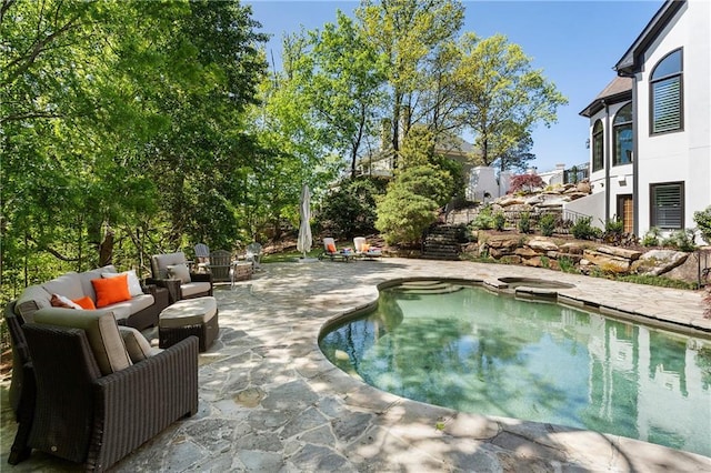 view of pool with a patio area, an outdoor living space, and a pool with connected hot tub