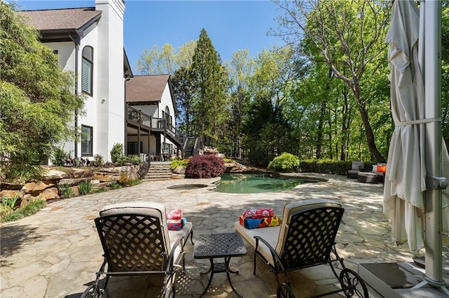 view of patio / terrace with an in ground hot tub and stairs