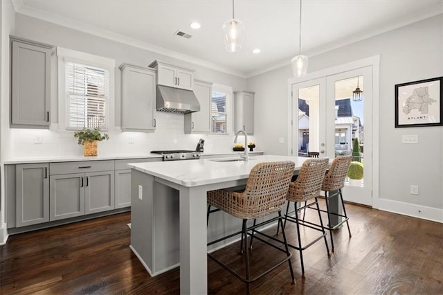 2005 Haley Walk, Woodstock, GA 30188 - kitchen with under cabinet range hood, a sink, gray cabinets, light countertops, and a kitchen breakfast bar