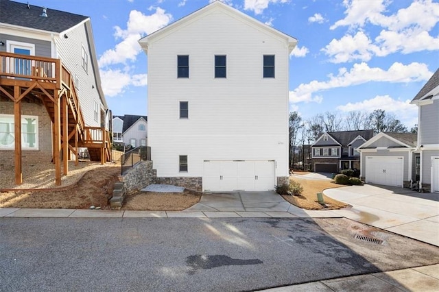2005 Haley Walk, Woodstock, GA 30188 - back of house with stairs, a residential view, concrete driveway, an attached garage, and a deck