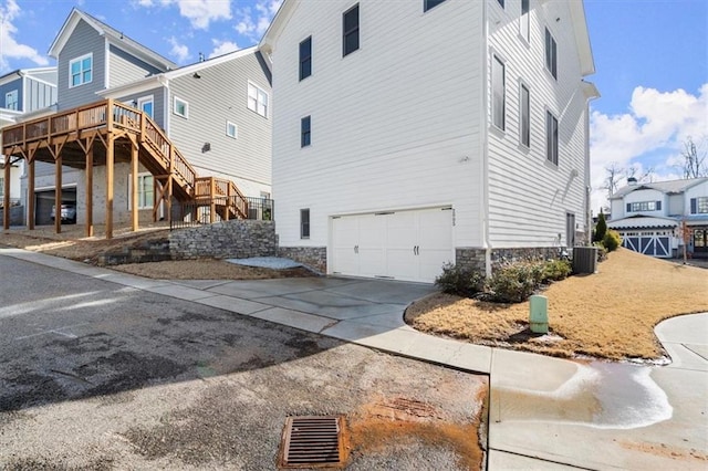 2005 Haley Walk, Woodstock, GA 30188 - view of property exterior featuring stone siding, a garage, stairs, a deck, and cooling unit