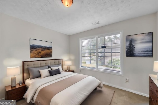 carpeted bedroom featuring a textured ceiling