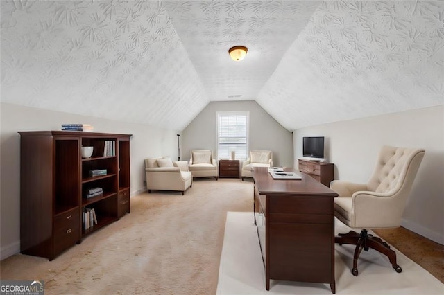 office area with vaulted ceiling, light carpet, and a textured ceiling