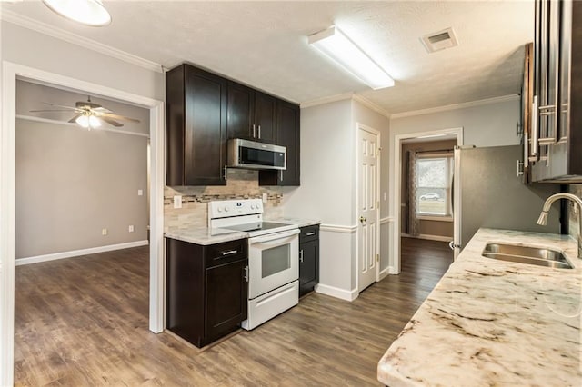 kitchen featuring tasteful backsplash, stainless steel microwave, dark wood finished floors, white electric stove, and a sink