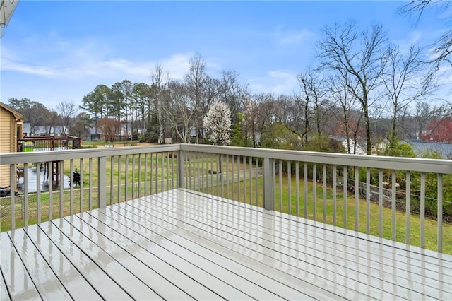 wooden deck featuring a lawn