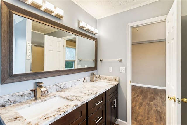 bathroom featuring a sink, baseboards, and double vanity