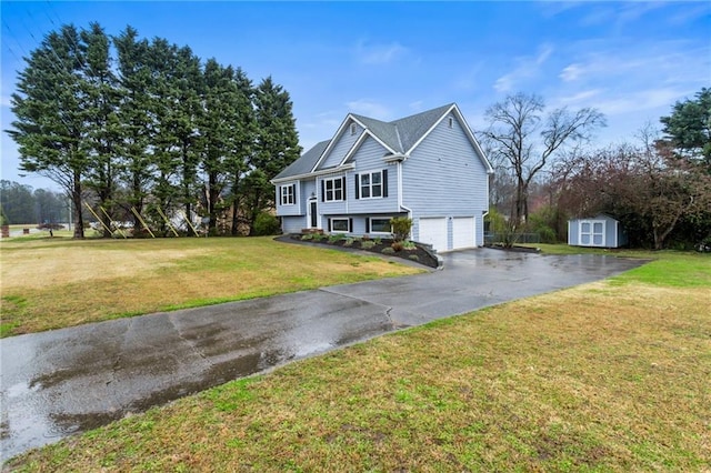 raised ranch featuring a front lawn, aphalt driveway, a shed, an outdoor structure, and an attached garage