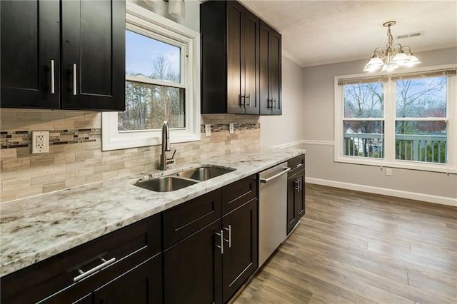 kitchen featuring visible vents, light wood-style flooring, ornamental molding, a sink, and dishwasher