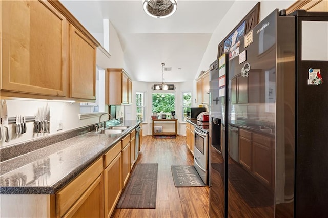 5102 Yellow Stone Dr, Flowery Branch, GA 30542 - kitchen featuring appliances with stainless steel finishes, a sink, light wood finished floors, decorative light fixtures, and vaulted ceiling