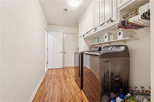 5102 Yellow Stone Dr, Flowery Branch, GA 30542 - laundry room featuring light wood-type flooring, washing machine and clothes dryer, cabinet space, and baseboards