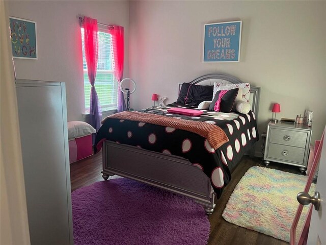 bedroom with dark hardwood / wood-style flooring