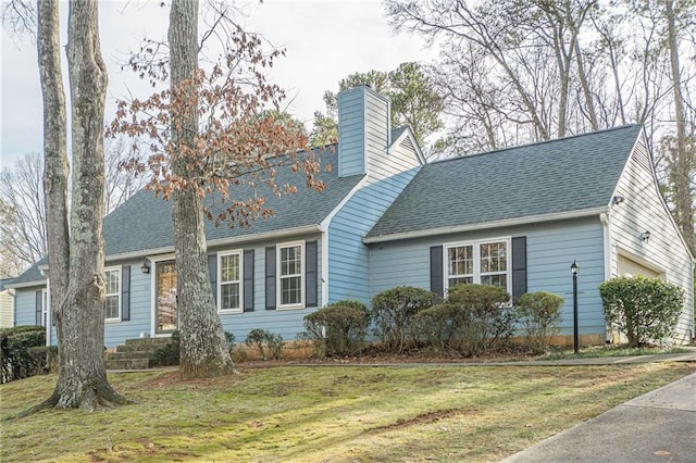 new england style home featuring a garage and a front lawn