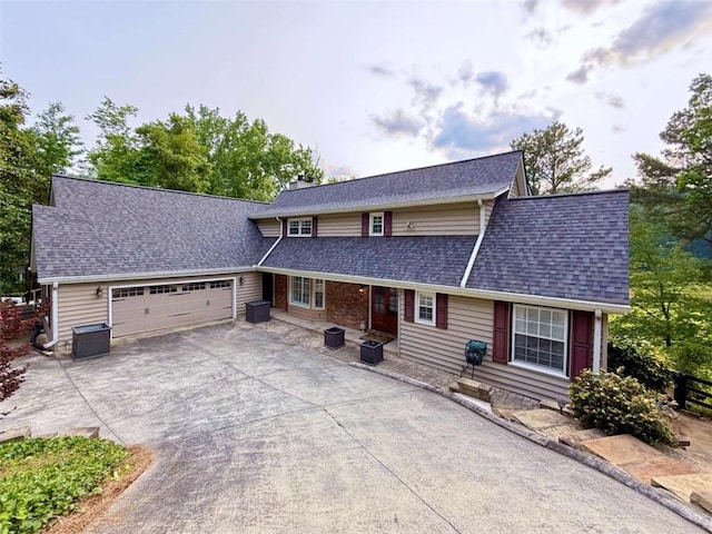 8710 Mount Rushmore Dr, Johns Creek, GA 30022 - view of front of house with an attached garage, driveway, a chimney, and a shingled roof