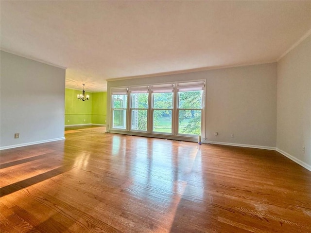 8710 Mount Rushmore Dr, Johns Creek, GA 30022 - spare room with a chandelier, baseboards, wood finished floors, and crown molding