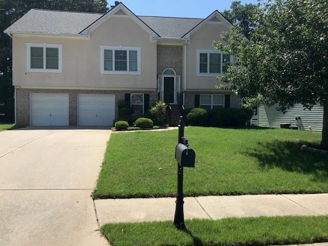 318 Summit View Dr, Mcdonough, GA 30253 - bi-level home with driveway, a front yard, brick siding, a garage, and stucco siding