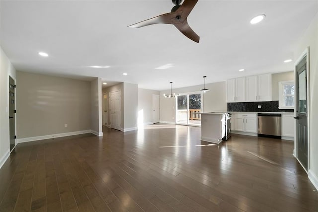 kitchen featuring dark hardwood / wood-style flooring, stainless steel dishwasher, backsplash, pendant lighting, and white cabinets