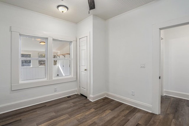 spare room with dark hardwood / wood-style flooring and crown molding