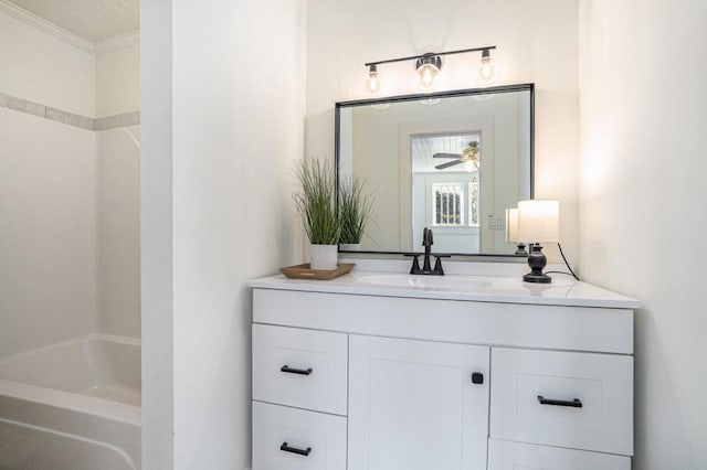 bathroom featuring washtub / shower combination, vanity, ceiling fan, and ornamental molding