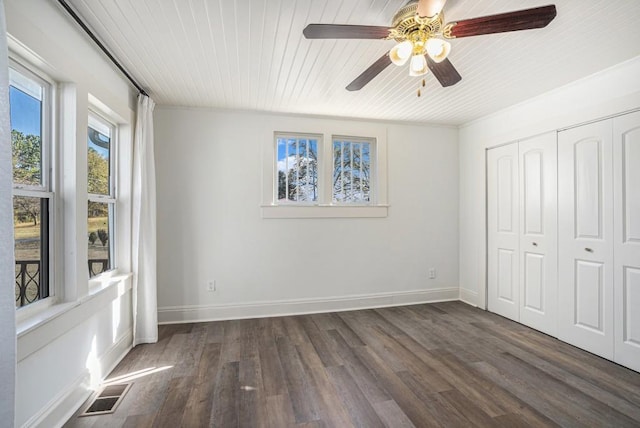 unfurnished bedroom with ceiling fan, a closet, and dark hardwood / wood-style floors