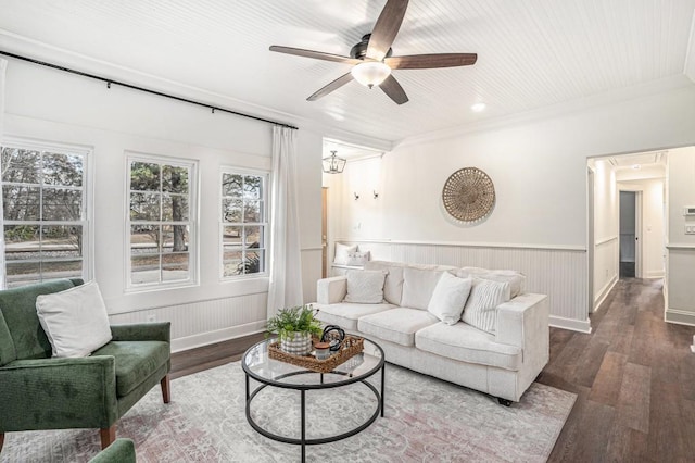 living room featuring dark hardwood / wood-style flooring, ceiling fan, and crown molding