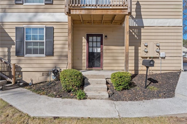 view of exterior entry featuring crawl space and a balcony