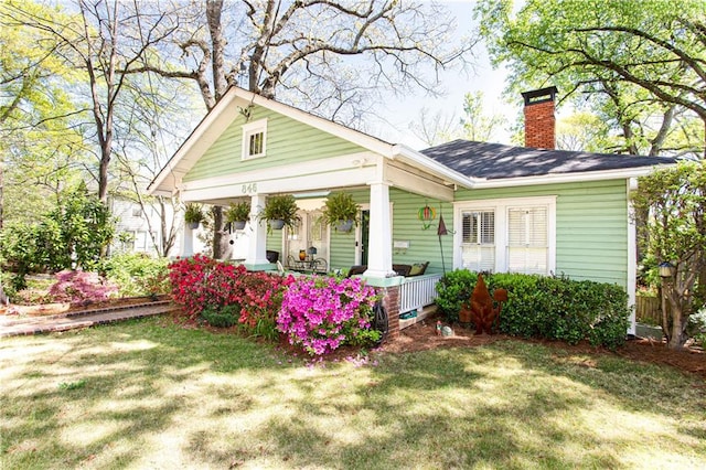 exterior space with covered porch and a yard