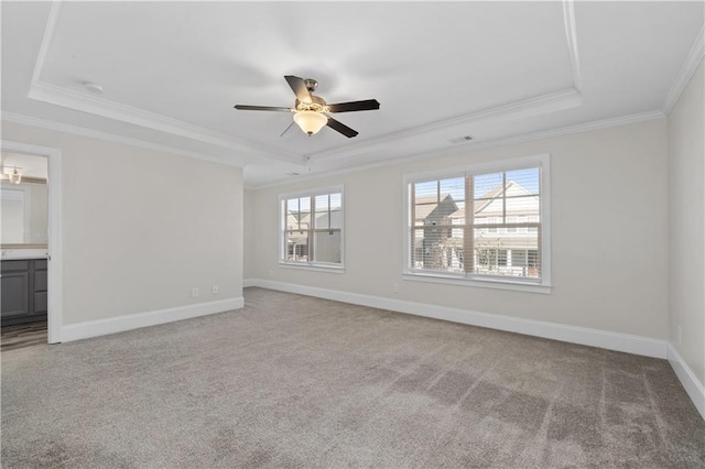 spare room featuring a raised ceiling, ceiling fan, a wealth of natural light, and ornamental molding