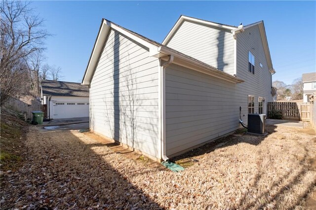 view of side of home featuring cooling unit and a garage