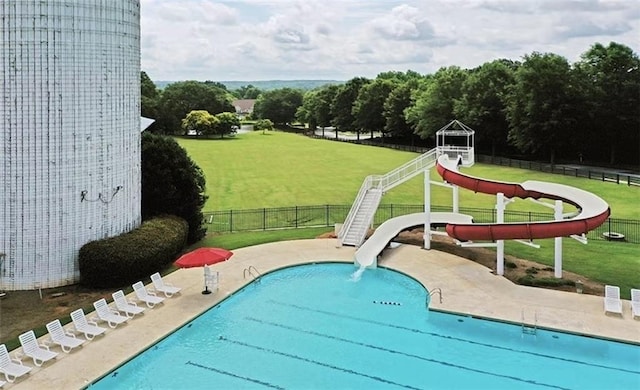 view of swimming pool with a lawn and a water slide