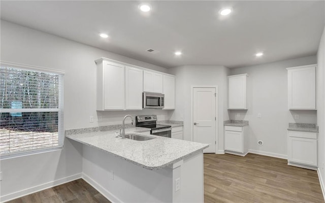 kitchen with stainless steel appliances, white cabinets, and kitchen peninsula