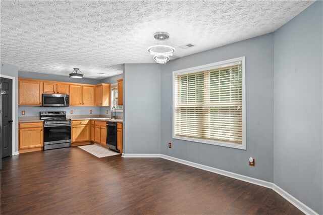 152 Maxton Ave, Dallas, GA 30132 - kitchen featuring stainless steel appliances, dark wood-style floors, light countertops, baseboards, and a chandelier