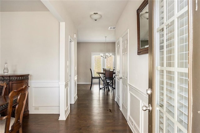 3013 Nicholas Dr, Villa Rica, GA 30180 - corridor with a chandelier, dark wood-style flooring, a decorative wall, and a wainscoted wall
