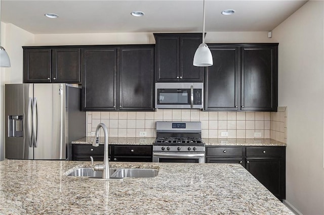 3013 Nicholas Dr, Villa Rica, GA 30180 - kitchen with appliances with stainless steel finishes, a sink, hanging light fixtures, light stone countertops, and backsplash