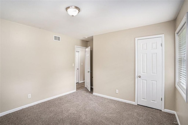 unfurnished bedroom featuring visible vents, carpet flooring, and baseboards