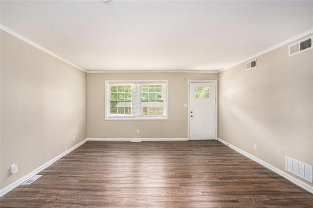 spare room with ornamental molding, dark wood-style flooring, and visible vents