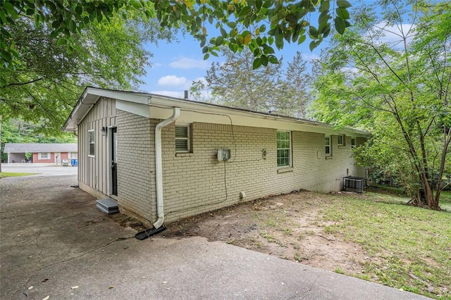 view of property exterior featuring central AC unit and brick siding