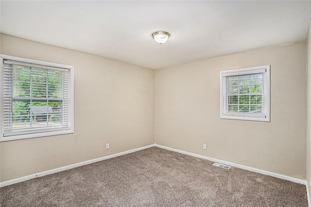carpeted spare room with baseboards and visible vents