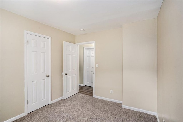 unfurnished bedroom with baseboards and carpet flooring