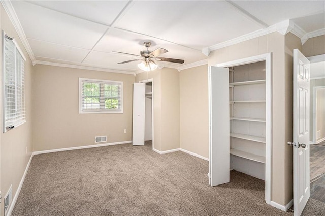unfurnished bedroom featuring carpet, two closets, baseboards, visible vents, and ornamental molding