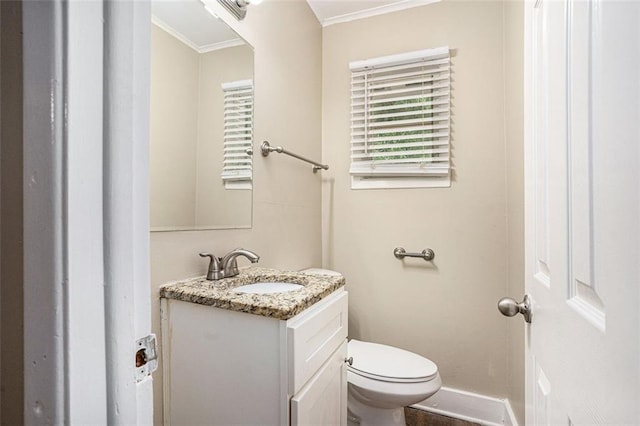 bathroom featuring crown molding, baseboards, toilet, and vanity