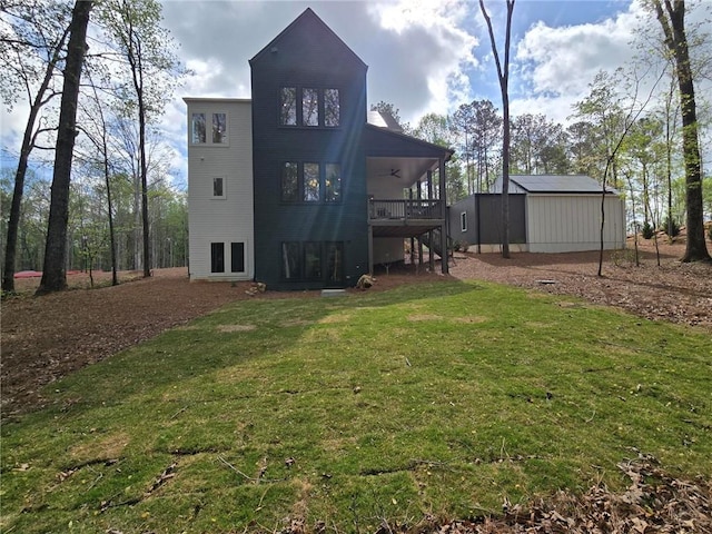 back of house featuring a lawn, ceiling fan, a wooden deck, and stairway
